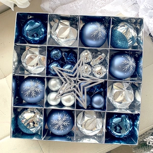 Macro view of blue and silver Christmas tree ornaments with snowflakes in a gift box