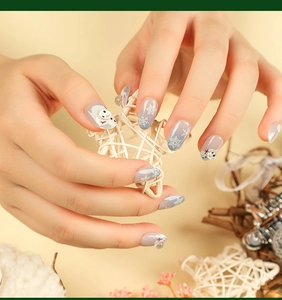 Detail view of Christmas press-on nails with white snowflakes and snowman patterns