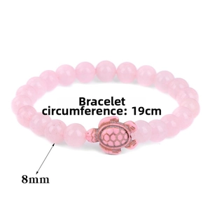 Detailed view of turtle charm and 8mm pink stone beads on 19cm beaded bracelet