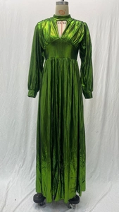 Detailed view of emerald green metallic fabric texture and elegant pleated waistline design