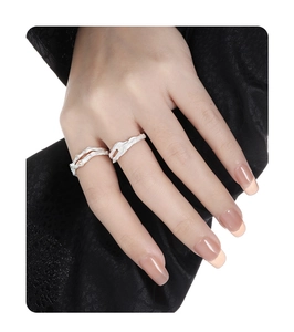 Macro detail of silver branch textured open rings with micro-set diamonds on model