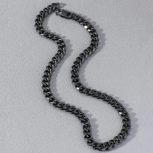 Close-up of gun grey Cuban link necklace with square clasp on textured grey surface