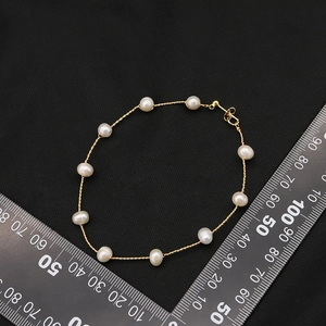 Vintage 18K gold-plated beaded earring hoops with white irregular pearls on black velvet