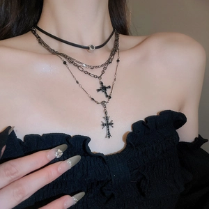 Dettaglio della collana punk a strati con croce di strass e girocollo in pelle nera