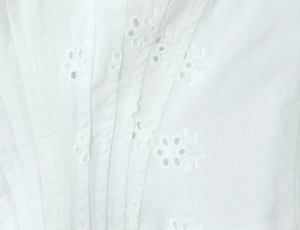 Gros plan détaillé du tissu blanc plissé avec broderie florale en dentelle fine