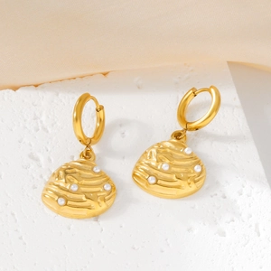 18K gold shell earrings with inlaid pearls on natural white stone and beige fabric