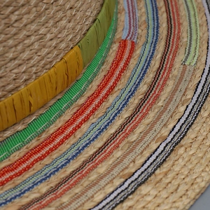 Close-up of bohemian straw sun hat with detailed multi-colored woven stripes texture