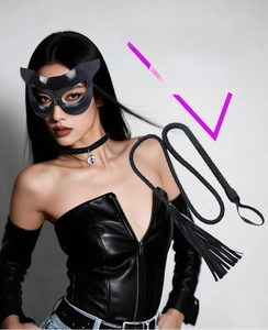 Detail of black leather cat mask and braided whip set for masquerade parties
