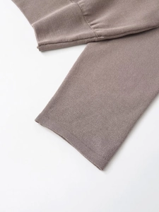 Close-up of ribbed cuffs on brown-grey soft knit sweater with fine stitching details