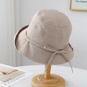 Détail du chapeau de soleil beige avec texture à carreaux et noeud élégant