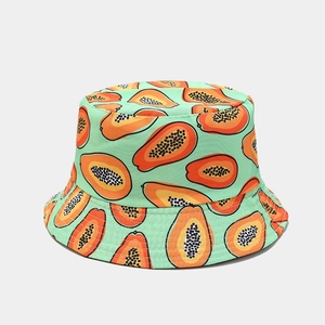 Detail of light green bucket hat featuring bright orange tropical papaya fruit prints