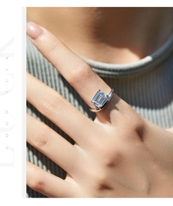 Detail showing an emerald-cut crystal ring in silver finish on a model finger