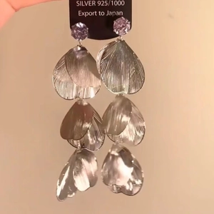 Macro shot of silver layered rose petal tassel earrings with zircon stud and 925 silver tag