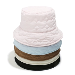 Detail of quilted bucket hats in multiple colors featuring heart pattern stitching texture