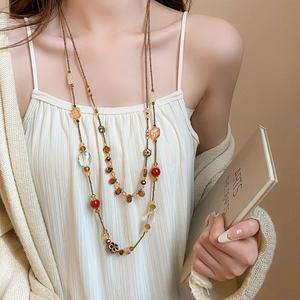 Detailed view of bohemian multilayer beaded necklace with amber and crystal resin accents