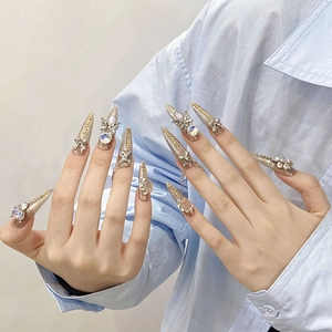Handmade stiletto press-on nails with champagne glitter, silver bows and rhinestones