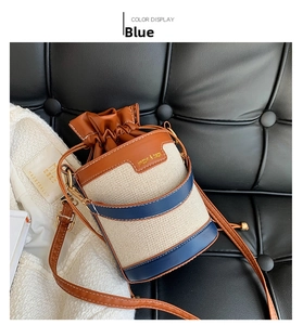 Detail of trendy color-block bucket bag in beige canvas and blue leather with drawstring