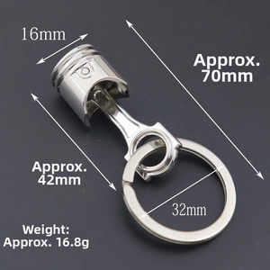 Detail of silver metal engine piston keychain with dimensions and industrial design