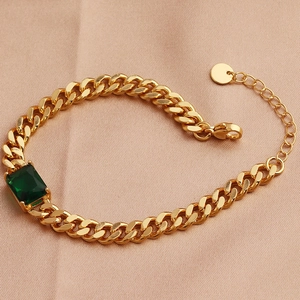Elegant gold cuban link bracelet with rectangular green zircon on silk background