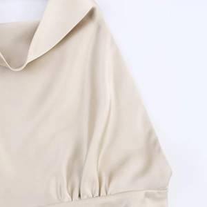 Détails de la robe en satin champagne avec col bénitier et finitions froncées élégantes