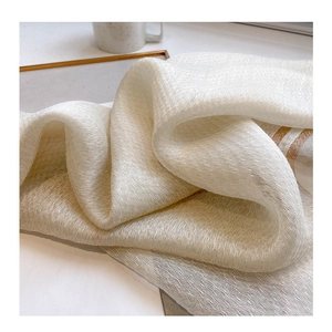 Macro detail of creamy silk-wool blend scarf fabric with elegant pleated texture