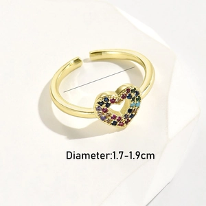 Macro shot of gold heart ring with rainbow zircon on white geometric base with size guide