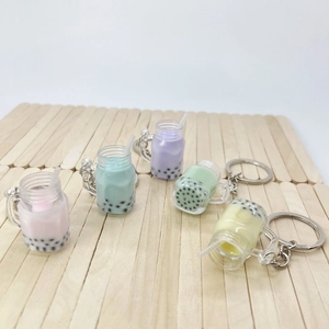 Macro shot of colorful miniature bubble tea keychains with silver metal clips on wood