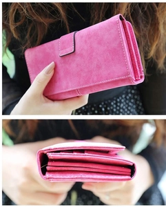 Detalle de cartera larga rosa con pliegues de acordeón y cierre de botón a presión