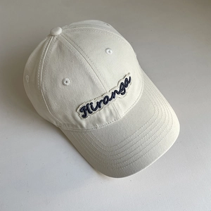 Close-up detail of 'Hiranga' embroidery on a beige cotton canvas baseball cap