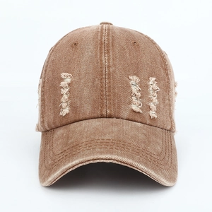 Close-up of distressed vintage baseball cap detailing with washed denim and ripped holes