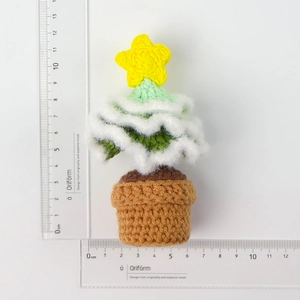 Detailed view of handmade crochet Christmas tree in pot with measuring tape for size