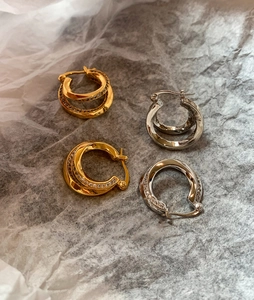 Close-up of double-layered geometric hoop earrings with sparkling zircon inlay