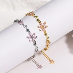 Detailed shot of pink cherry blossom bracelets in gold and silver with adjustable chains