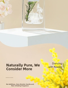Macro view of clear glass diffuser with preserved white flowers and green botanicals