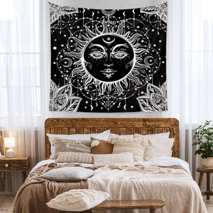 Detail view of black and white bohemian sun and moon tapestry hanging in a cozy bedroom