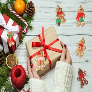 Close-up of six creative gingerbread man ornaments on white wooden background