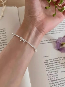 Dettaglio macro del bracciale a fiocco d'argento con catena intrecciata su sfondo
