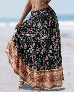 Detail of high waisted bohemian floral maxi skirt showing vintage hem print on beach