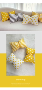 Close-up of velvet bow-shaped pillows with stripe and polka dot patterns on a sofa