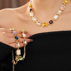 Detail view of vintage gold necklace and bracelet set with colorful square-cut gemstones