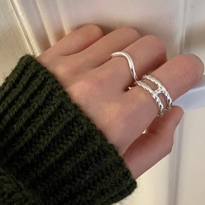 Close-up of stacked sterling silver double-layered H-shaped ring on a finger