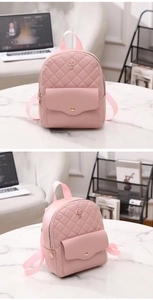 Detailed view of pink quilted mini backpack with metal rose ornament and front flap pocket