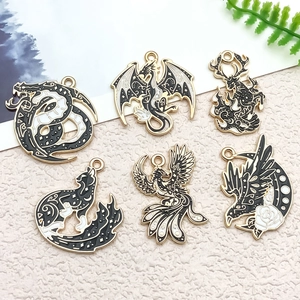 Macro shot of mythic dragon and phoenix enamel charms with black white and gold details