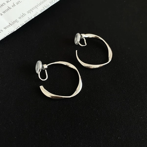 Macro detail of silver twisted hoop clip-on earrings with soft anti-pain pads