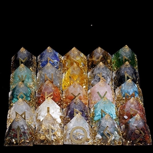 Set of 20 healing crystal energy pyramids with golden runes on a black reflective surface