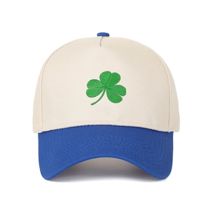 Detail of green shamrock embroidery on a five-panel cream and blue trucker hat