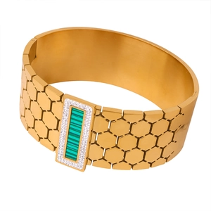 Polished gold hexagonal honeycomb cuff bracelet with rectangle emerald green center stone