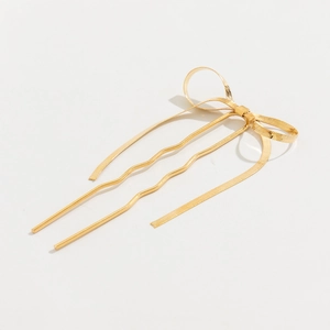 Detail of golden metal bow hair pin with snake chain texture and wavy double-prong design