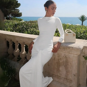Detail of the white long-sleeve dress featuring a waist twist knot and ruched design