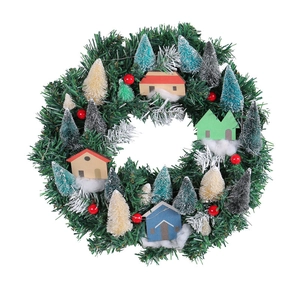 Illuminated Christmas wreath with miniature houses and colorful trees on white backdrop
